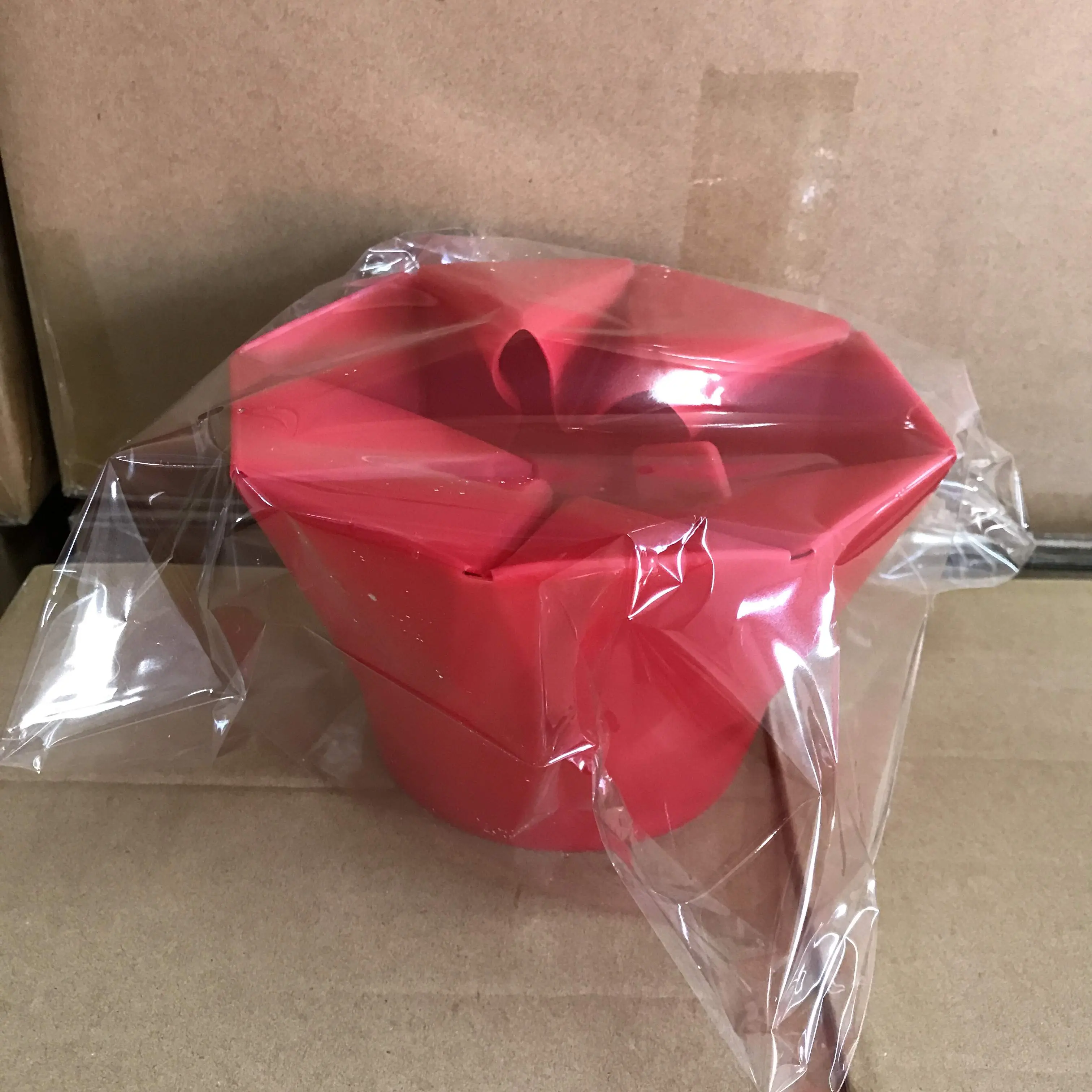 Crispetera roja en silicona, plegable y empacada, ideal para hacer palomitas en microondas.