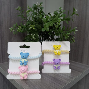 Moñitas espiral para cabello con dijes de ositos en colores azul, rosa, amarillo y lila.
