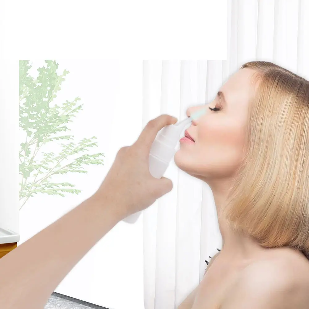 Mujer usa irrigador nasal portátil blanco para limpieza.