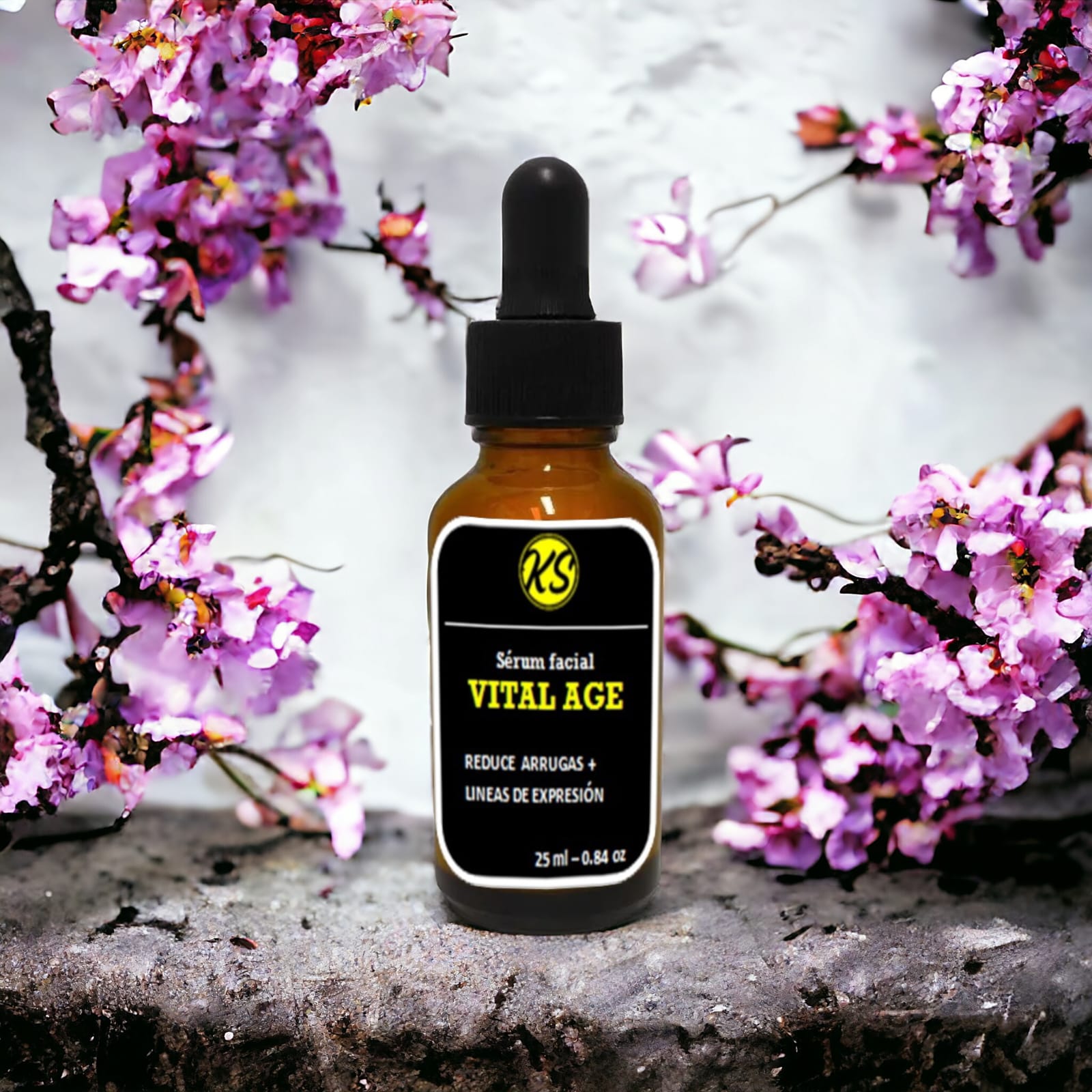 Serum facial Vital Age antiarrugas en frasco ámbar con gotero negro, rodeado de flores rosas.