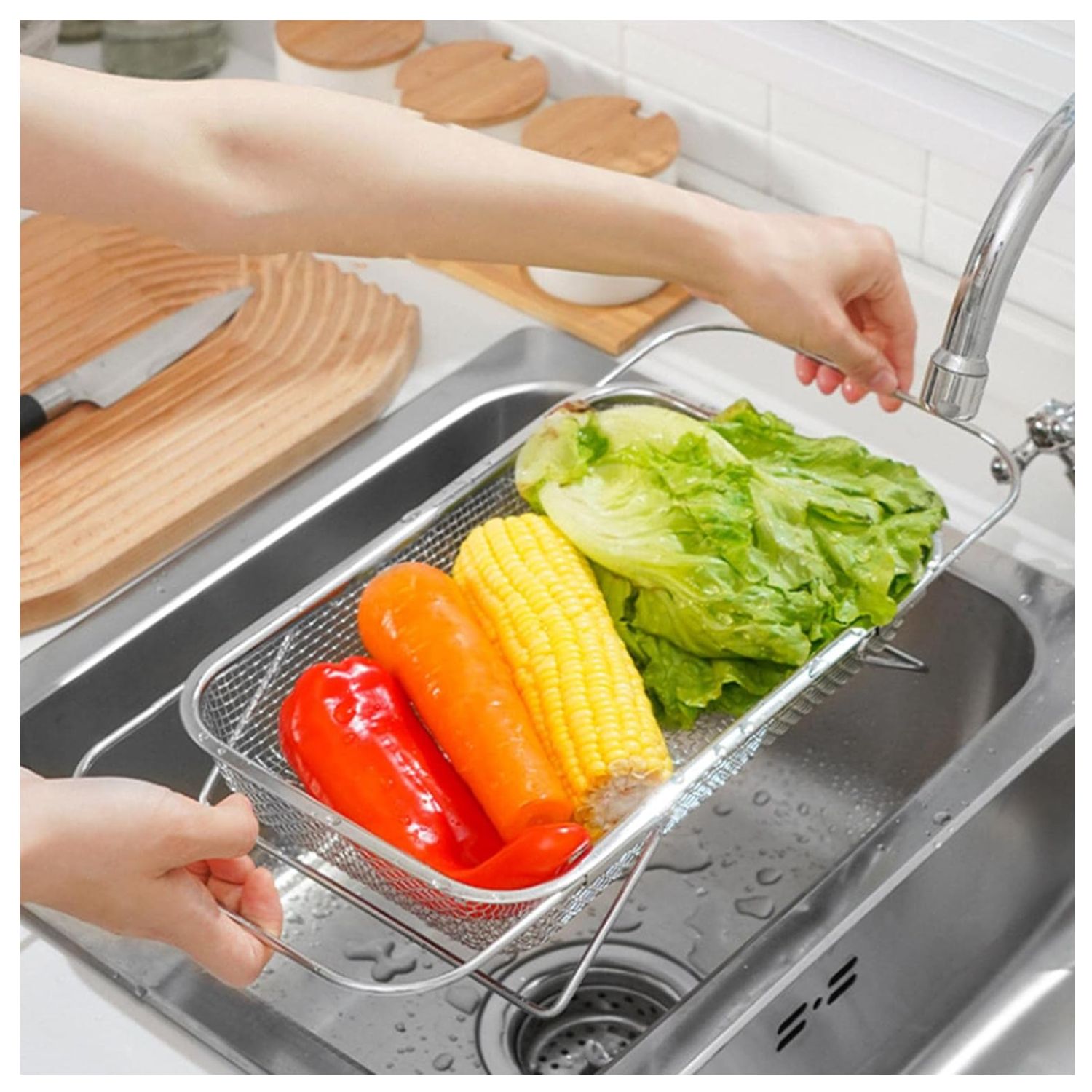 Escurridor expandible de acero inoxidable con lechuga, maíz y pimentón en un lavaplatos.