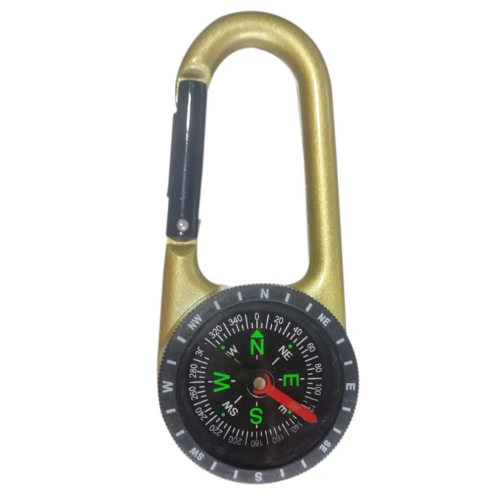 Brújula dorada con mosquetón, ideal para camping, con detalles de navegación y aguja verde apuntando al noreste.