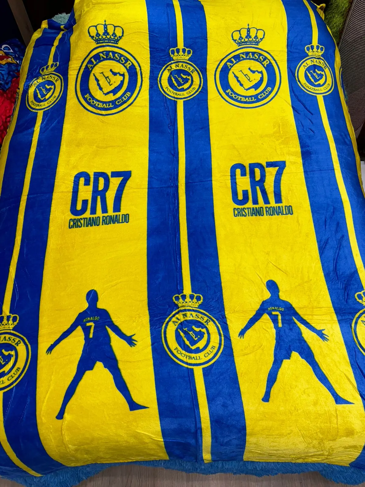 Cobija deportiva azul y amarilla de CR7 con silueta de jugador y logos de club.
