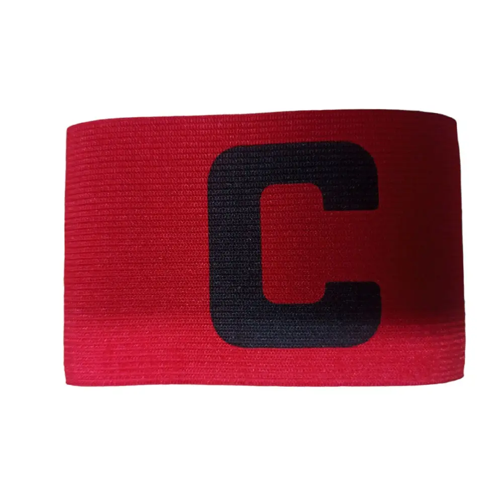 Brazalete de capitán de fútbol rojo con letra C negra, material elástico, usado en el brazo.