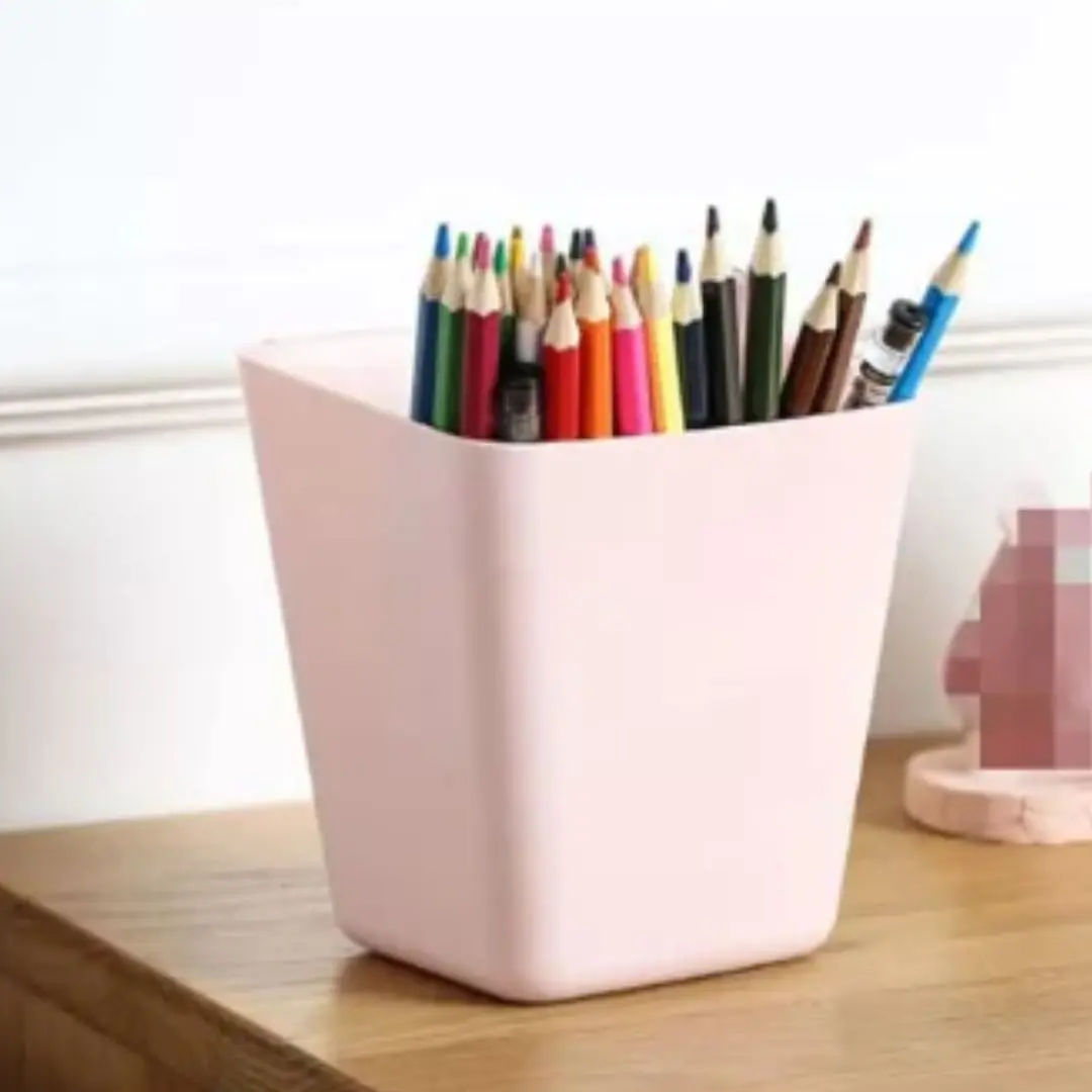 Cubo organizador de plástico rosa con lápices de colores para escritorio.