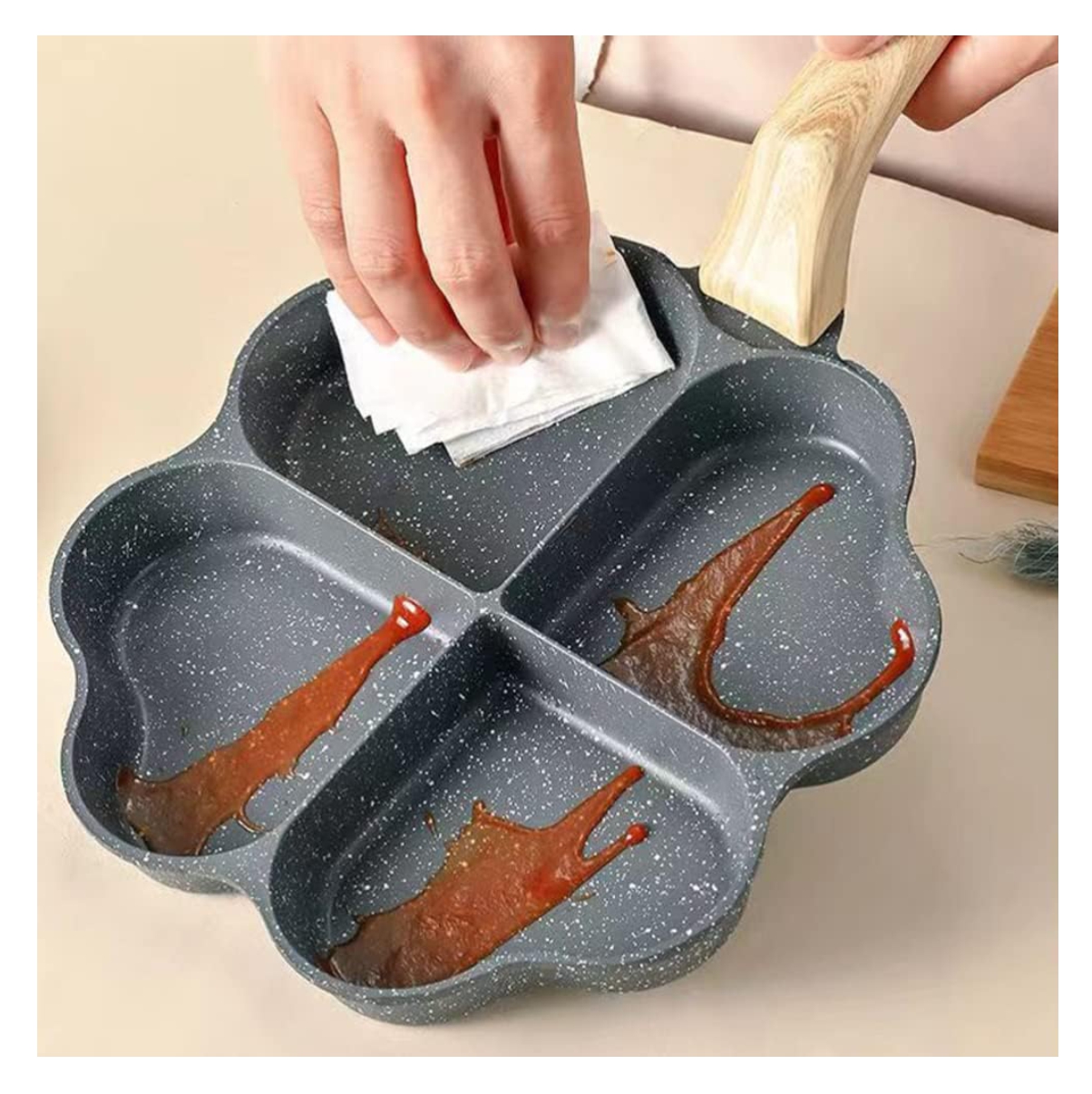 Sartén antiadherente gris con cuatro compartimentos en forma de corazón, lista para cocinar.