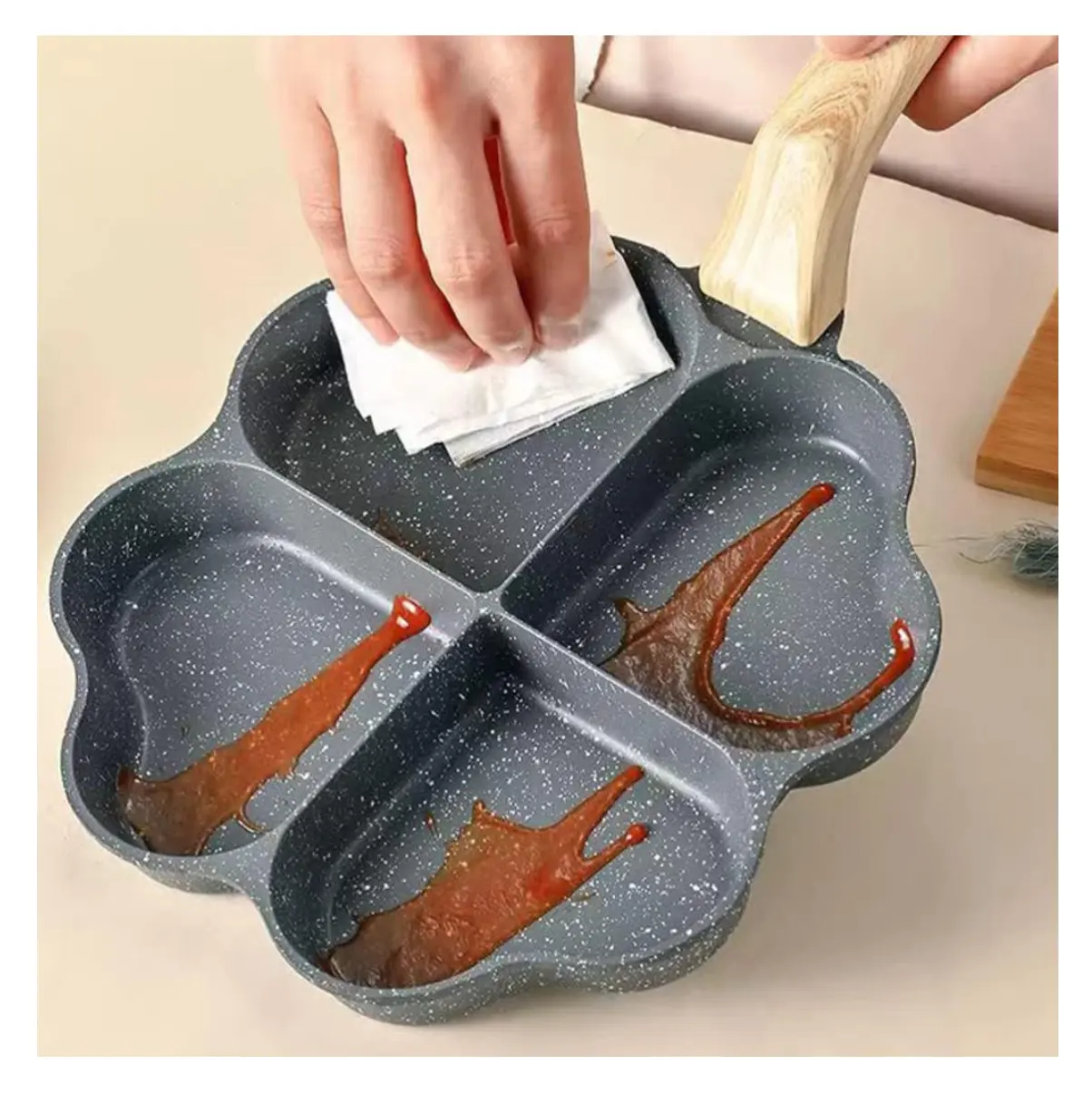 Sartén antiadherente gris con cuatro compartimentos en forma de corazón, lista para cocinar.