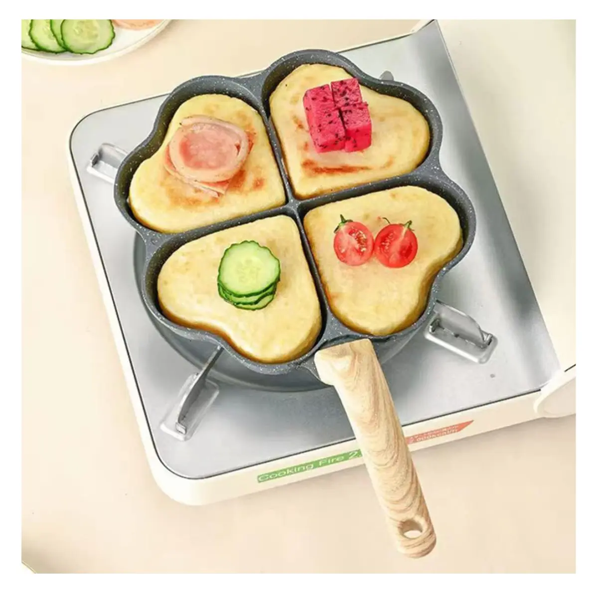 Sartén antiadherente de 4 cavidades en forma de corazón con base de cocina, toppings de jamón, pitahaya, pepino y tomates.