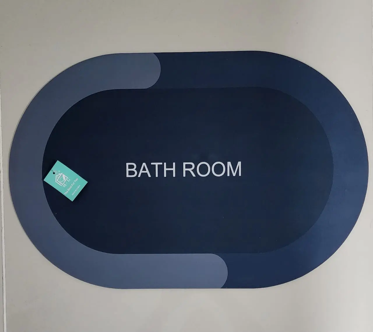 Tapete antideslizante ovalado azul oscuro para baño, con diseño moderno y etiqueta.