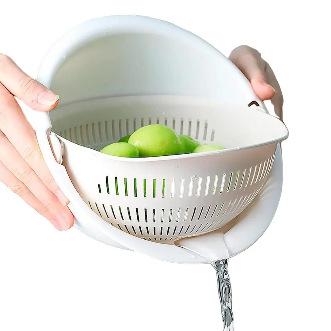 Colador escurridor blanco giratorio con verduras verdes, agua fluyendo por el lateral.