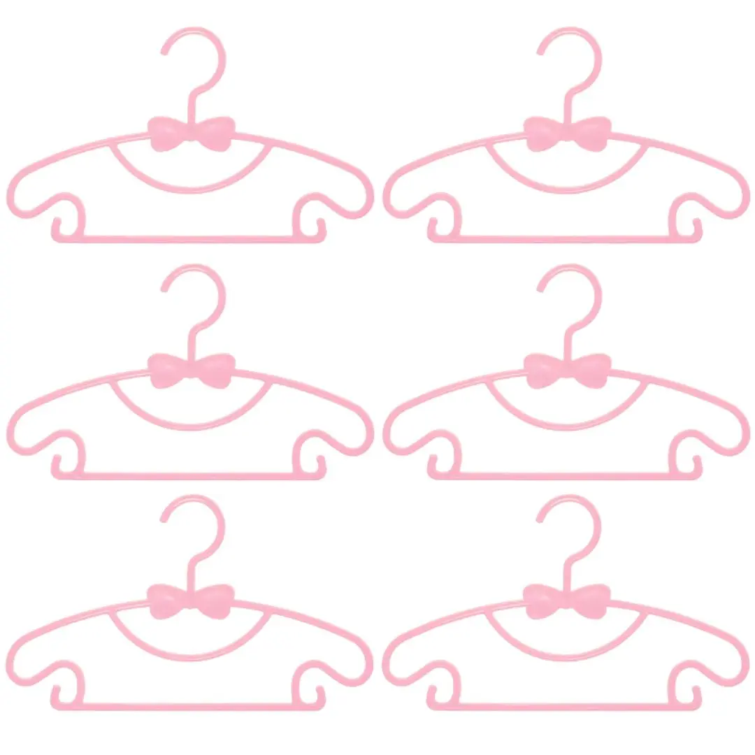 Kit 6 ganchos flexibles rosa para ropa de bebé, con forma de carita y detalles de moño, ideales para secar y organizar.