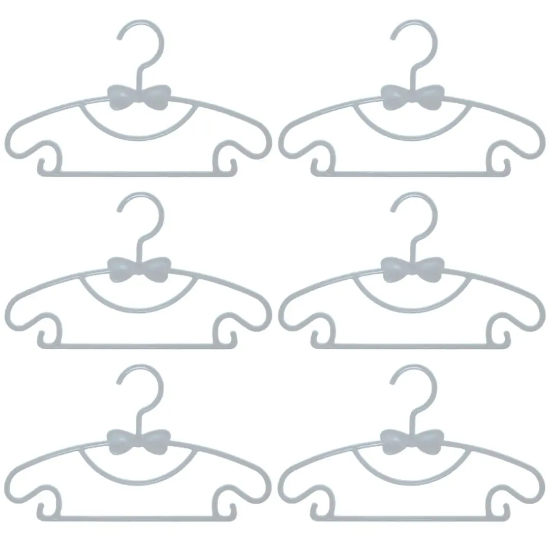 Seis ganchos flexibles para ropa de bebé en color gris con diseño de moño, ideales para organizar prendas infantiles.
