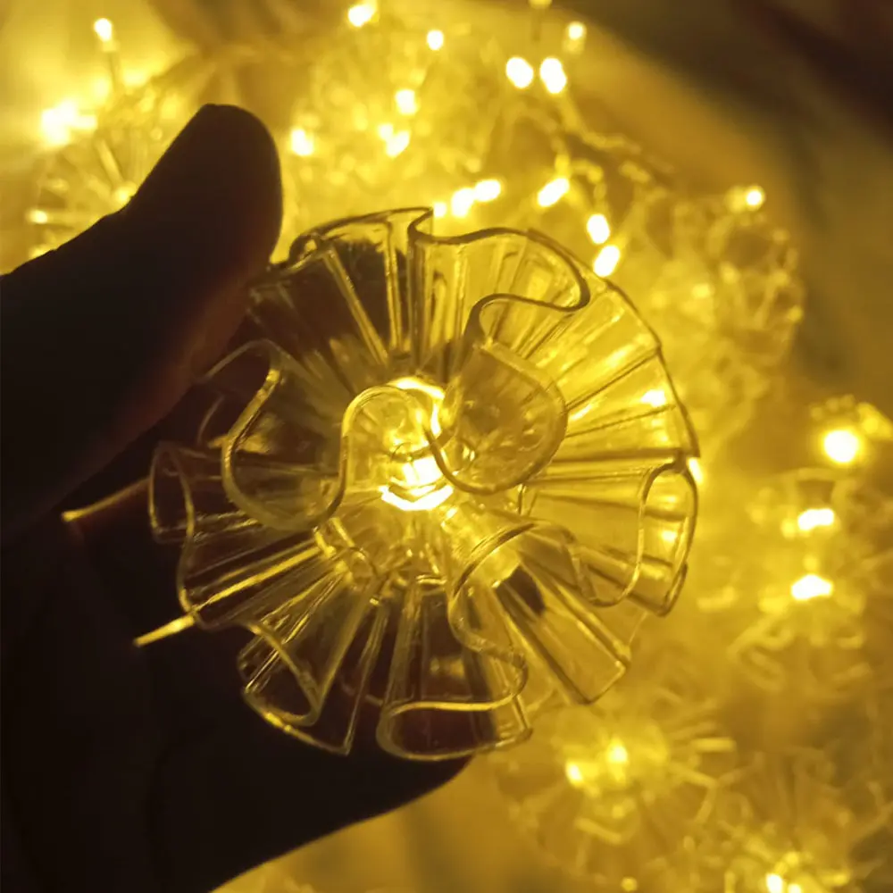 Cortina de luces LED navideñas con 3 metros de flores transparentes tipo campana, tono cálido.