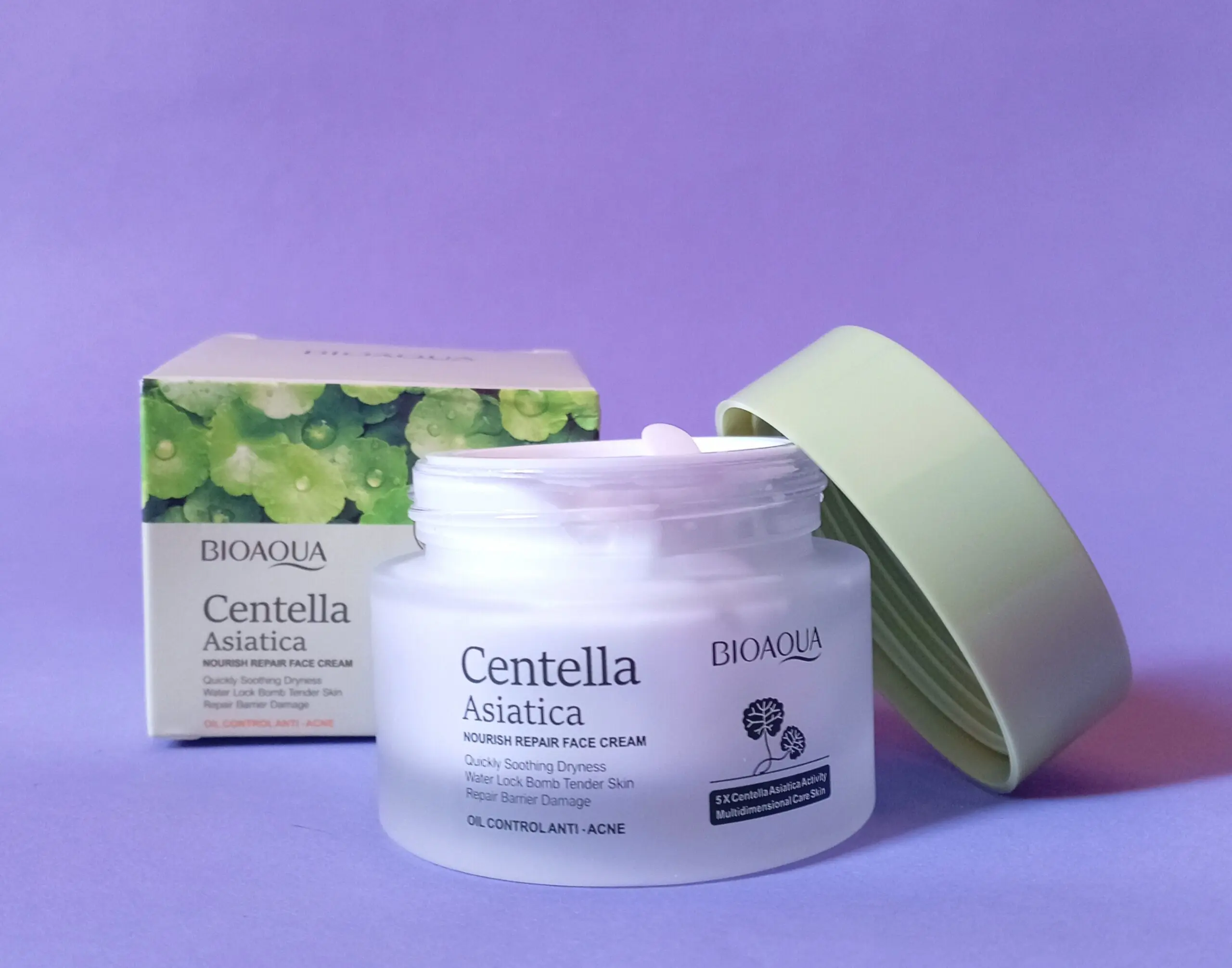 Crema facial BIOAQUA Centella Asiática en frasco blanco con tapa verde, caja con hojas verdes al fondo.