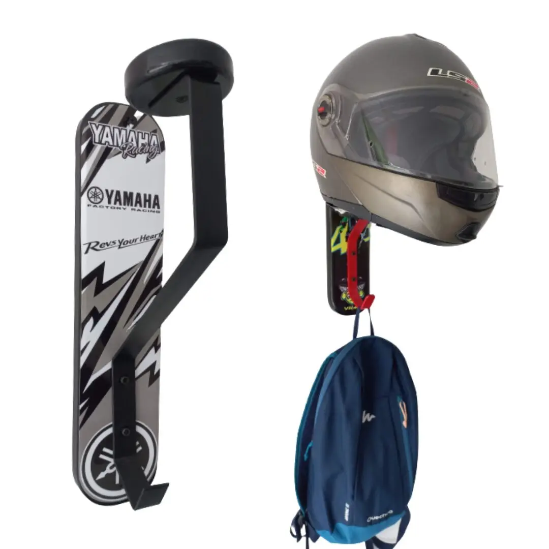 Portacasco mural negro de un puesto. Sostiene un casco gris oscuro y una mochila azul. A la izquierda, un tablero de skate con diseño Yamaha Racing pegado al soporte.