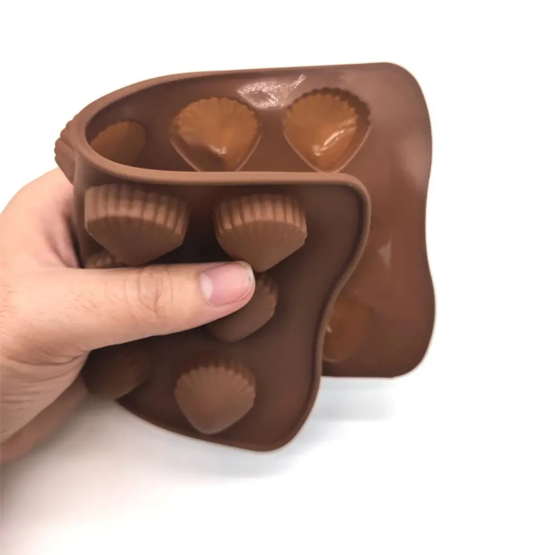 Molde de silicona marrón para 4 chocolates en forma de concha marina, flexible y fácil de usar.