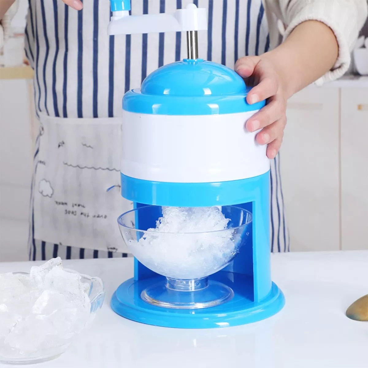 Triturador de hielo manual azul y blanco para hacer granizados.