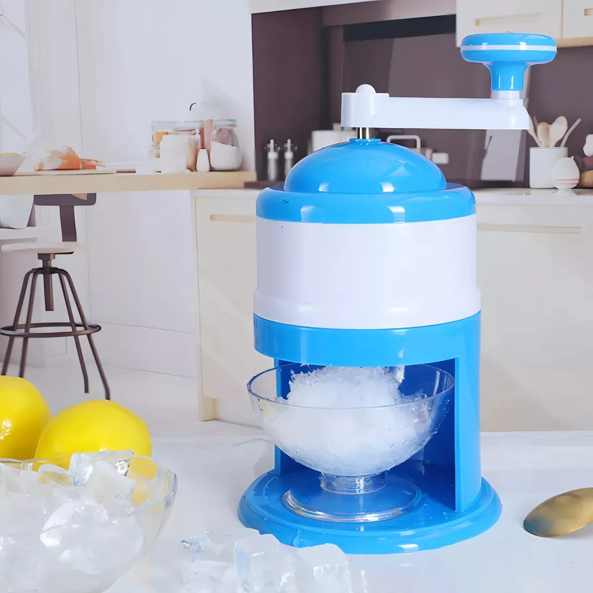 Triturador de hielo manual azul y blanco con manivela, picando hielo en recipiente de vidrio.