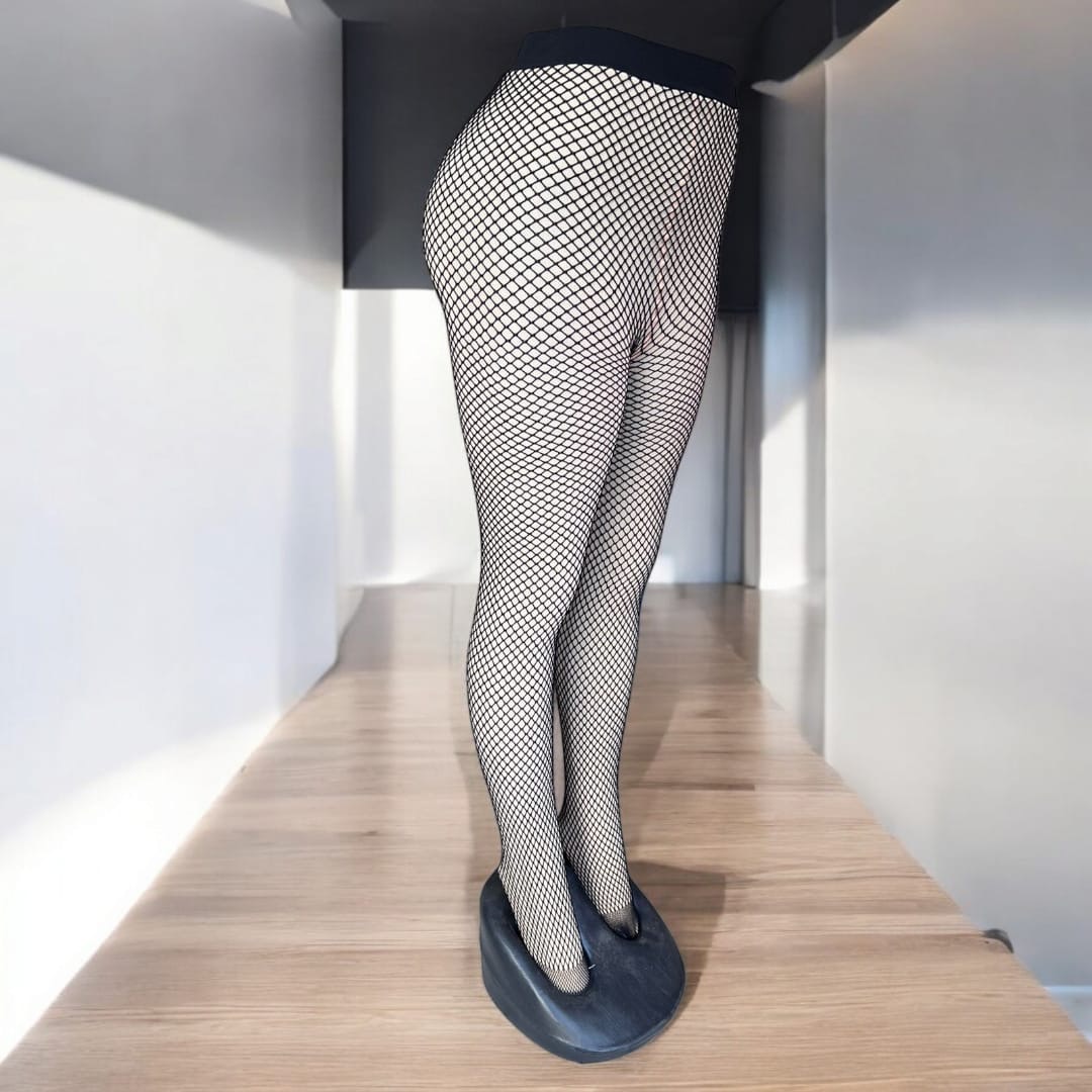 Piernas con medias térmicas de malla negra 80 gr, expuestas sobre tarima de madera.