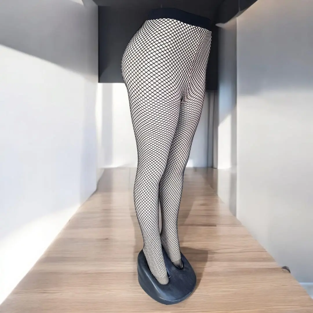 Piernas con medias térmicas de malla negra 80 gr, expuestas sobre tarima de madera.