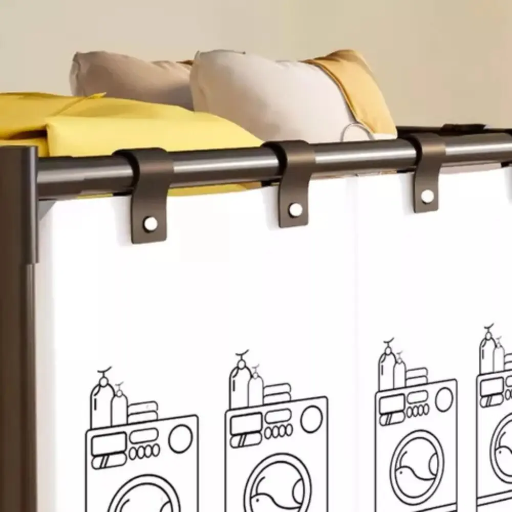 Cesta organizadora de ropa X1 con cortinas blancas decoradas con lavadoras, sobre rieles oscuros y cojines de fondo.