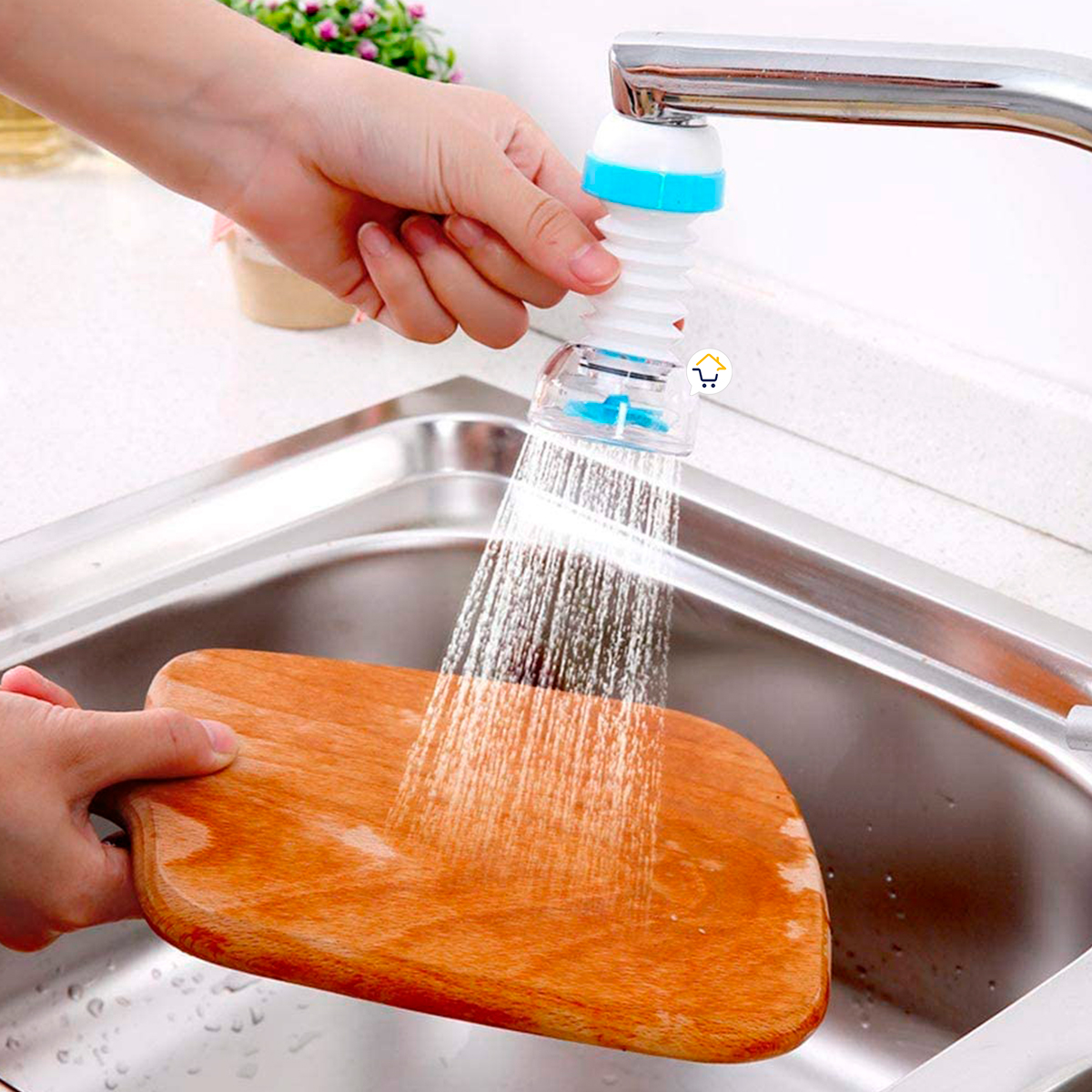 Ahorrador de agua flexible, blanco y azul, rociando agua sobre tabla de madera en un fregadero de cocina.