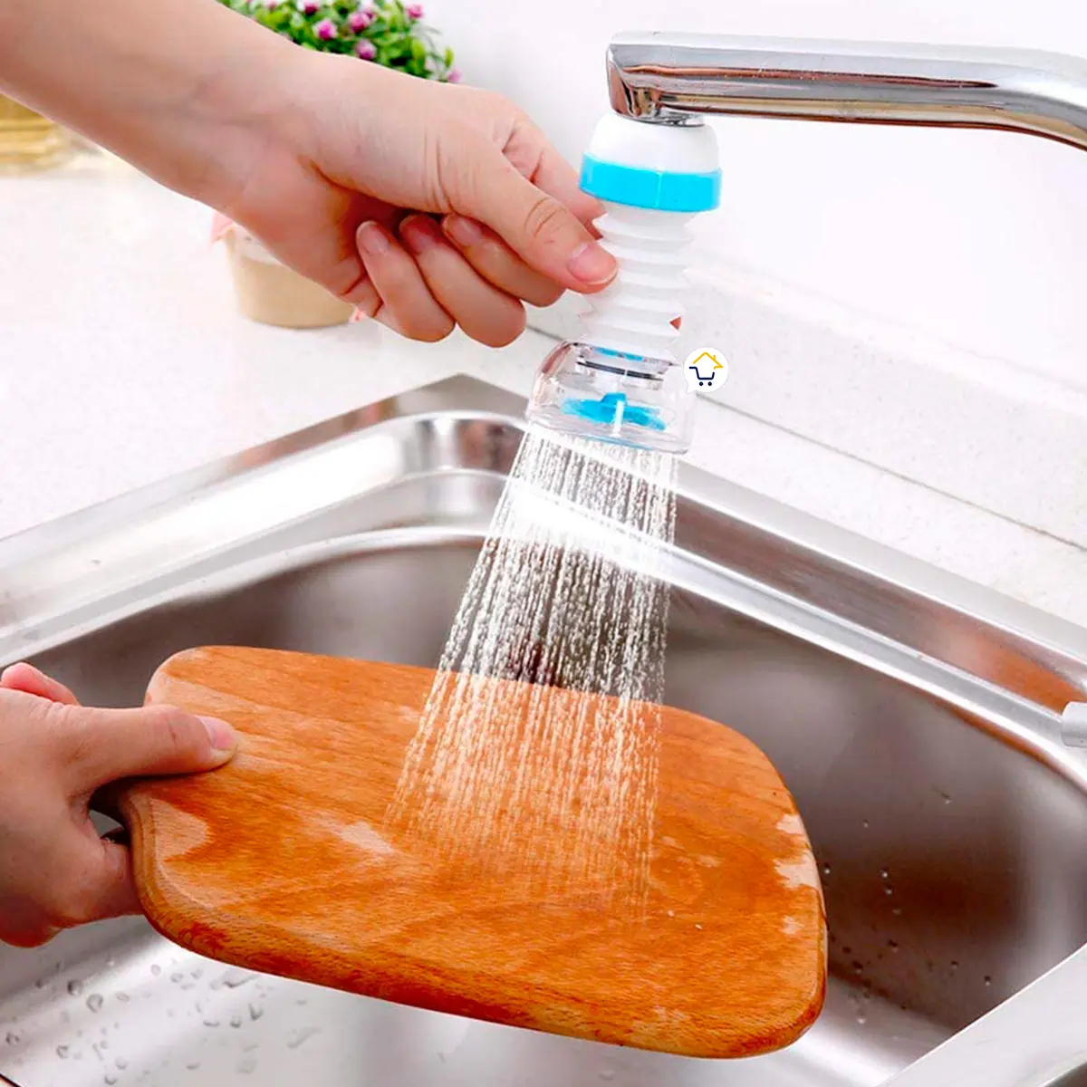 Ahorrador de agua flexible, blanco y azul, rociando agua sobre tabla de madera en un fregadero de cocina.