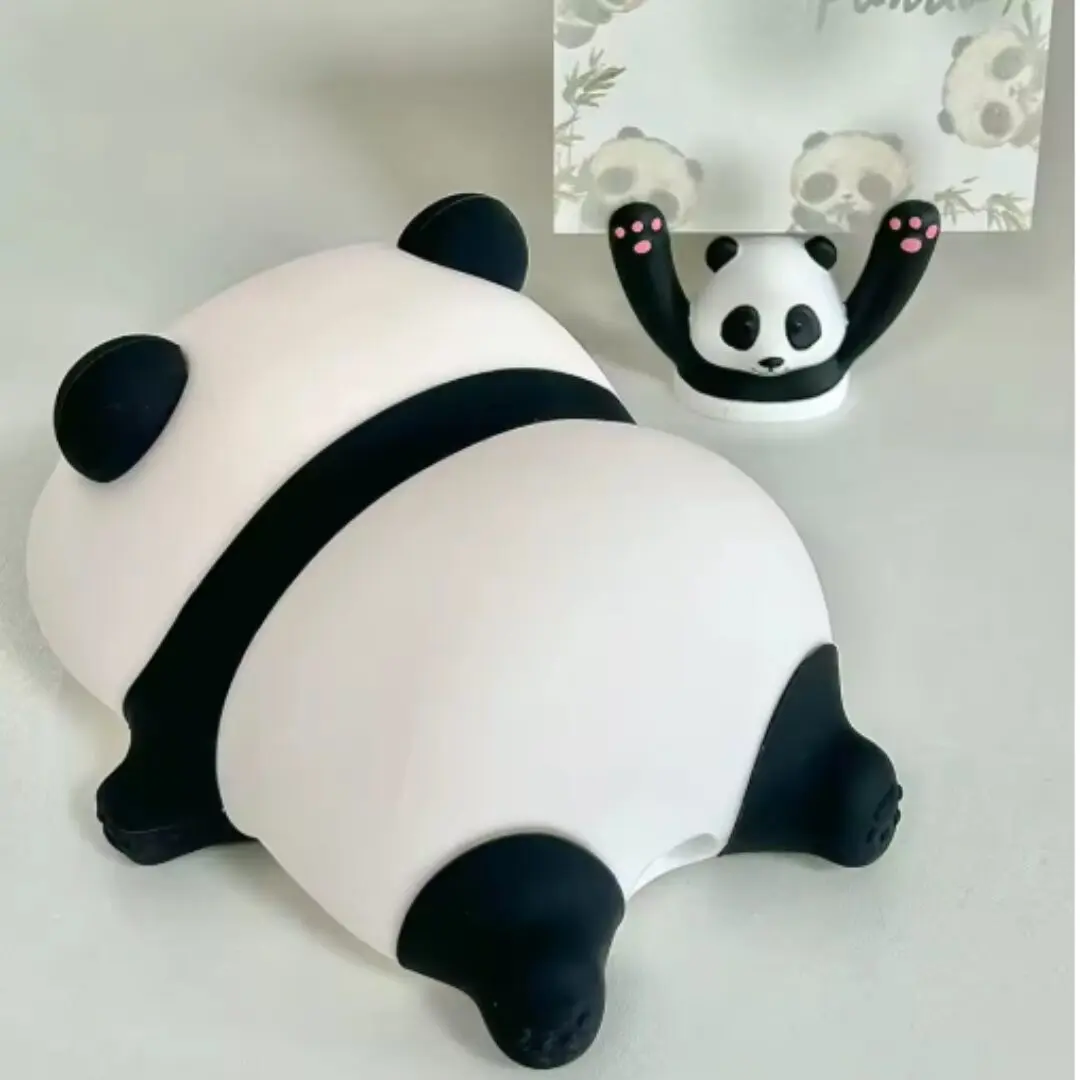 Lámpara de noche de silicona con forma de panda recostado junto a un pequeño soporte de panda con tarjeta, ambos con diseño decorativo en blanco y negro.
