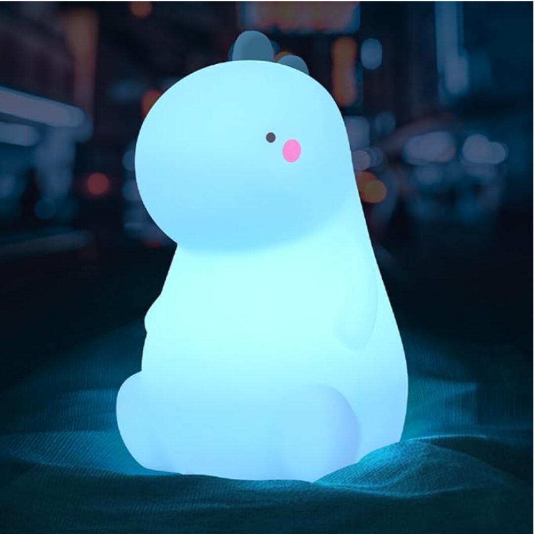 Lámpara de noche con forma de dinosaurio en silicona suave de color azul brillante, con mejillas rosadas, ideal para acompañar el sueño de los niños.