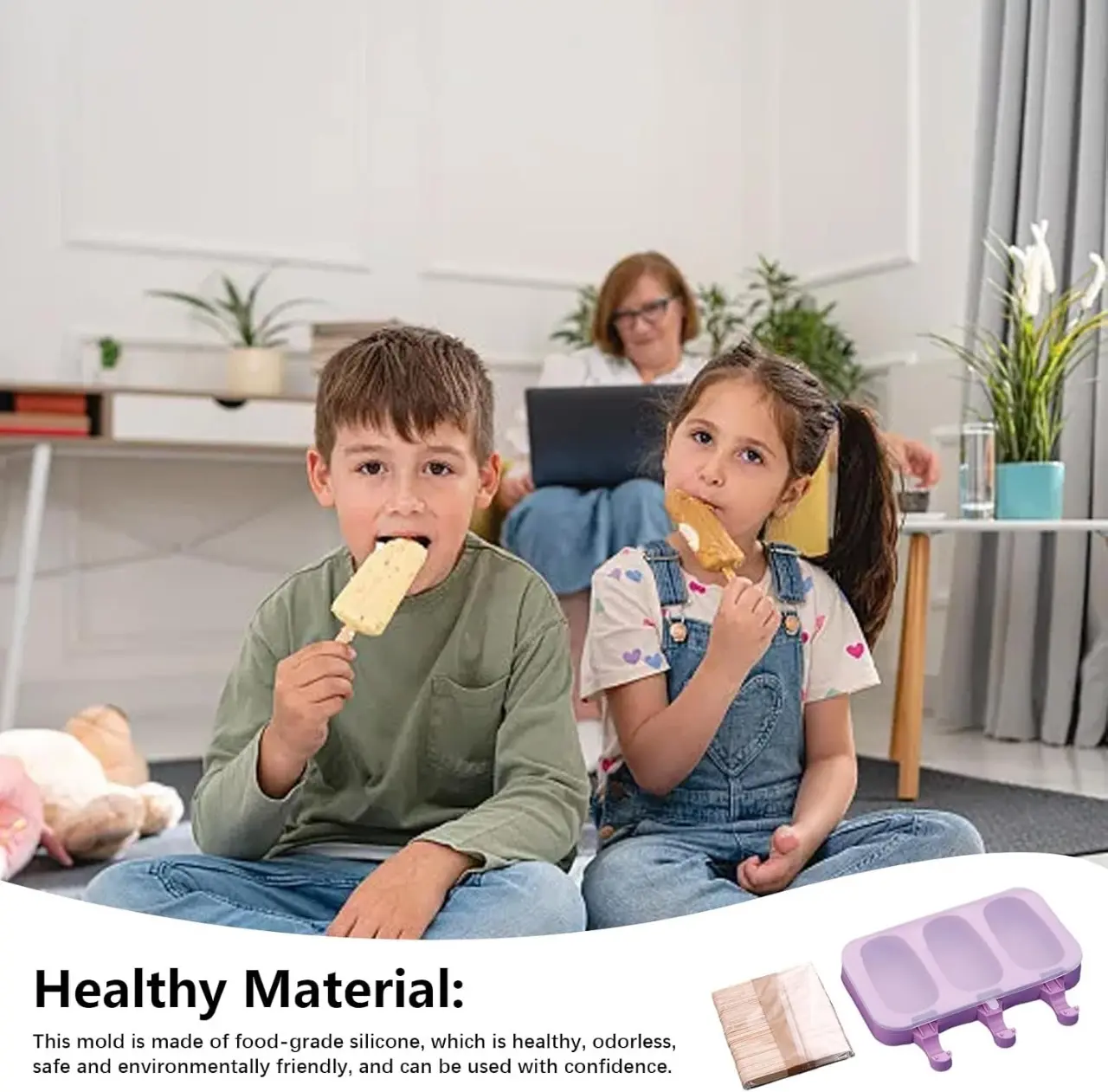 Niños comiendo paletas de helado caseras. A la derecha, molde de silicona morado para tres helados con tapa y paquete de palos de madera para helados.