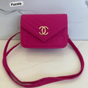 Cartera pequeña fucsia de cuero repujado con logo doble C dorado y correa larga.