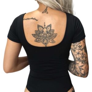Body manga corta negro con tatuajes de flor de loto y flores en la espalda y brazo.