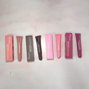 Cajas y tubos de Peptide Lip Tint R1642 en tonos rosa, marrón y fucsia sobre superficie clara.
