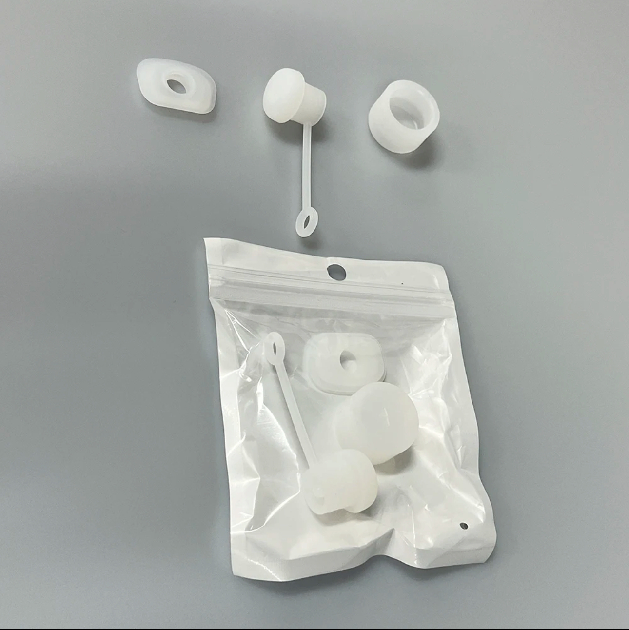 Kit antiderrame Stanley en silicona blanca: tres piezas sueltas y tres dentro de bolsa sellable.
