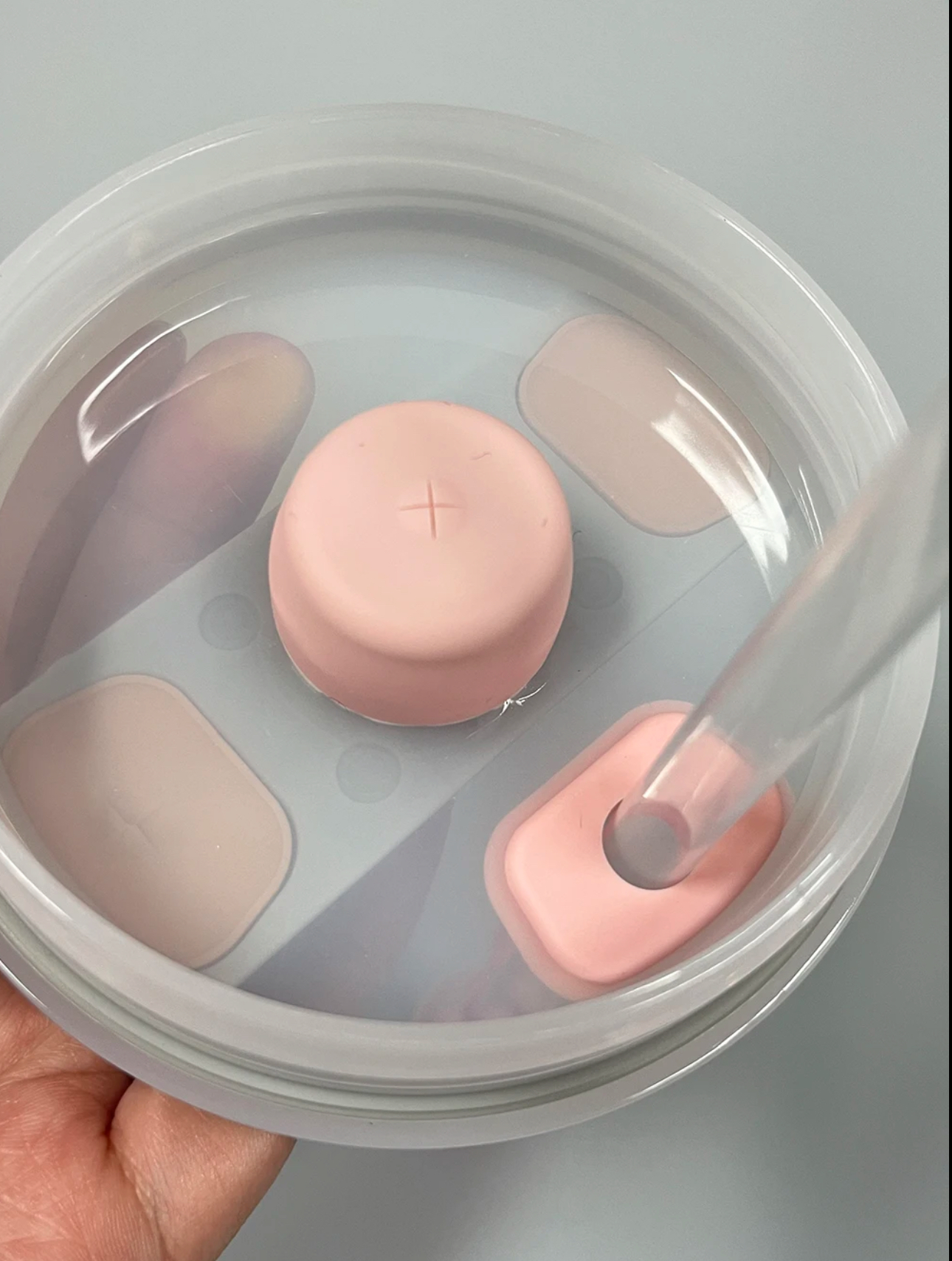 Kit antiderrame Stanley con tapa rosada y sorbete transparente en recipiente con agua.
