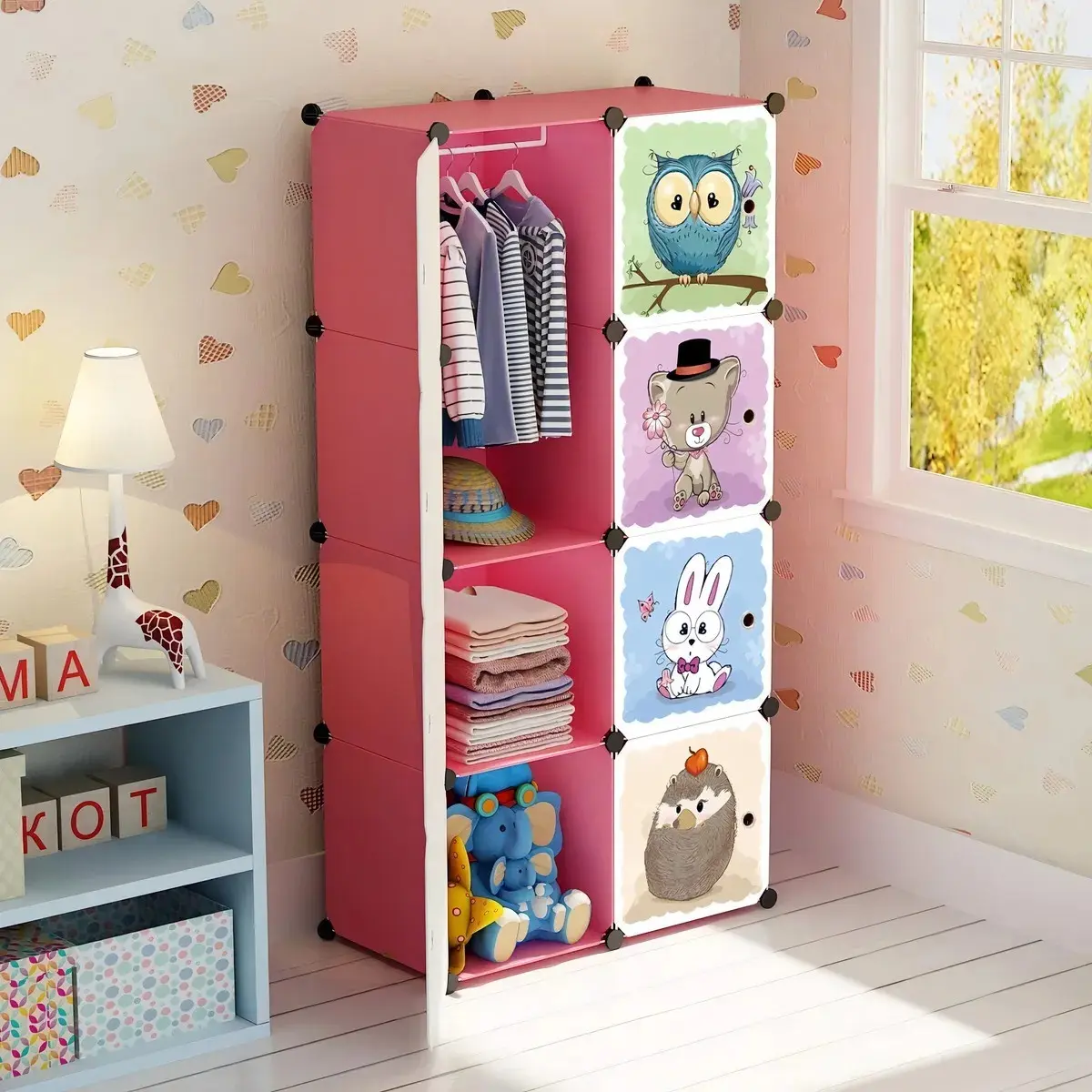 Armario organizador rosa de plástico con 6 cubos, uno con ropa colgada y otros con peluches, toalla y sombrero.