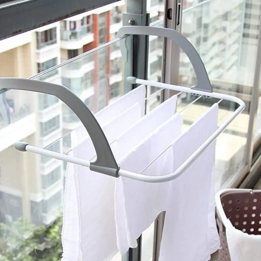 Colgador compacto gris para secar ropa en ventana o balcón, con barras blancas y toallas blancas colgando.