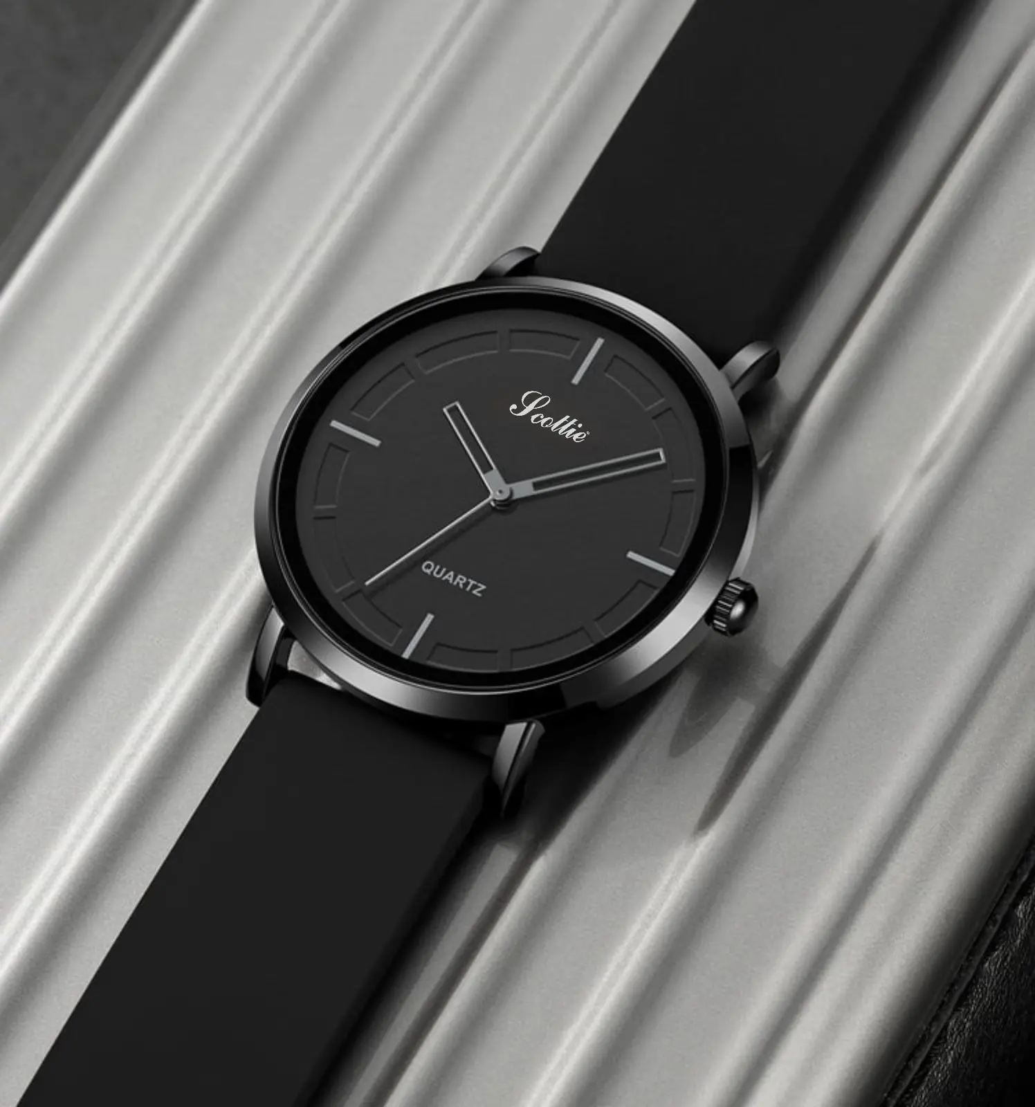 Reloj Scottie 2050 sumergible de silicona negra, diseño minimalista, fondo negro y manecillas plateadas.