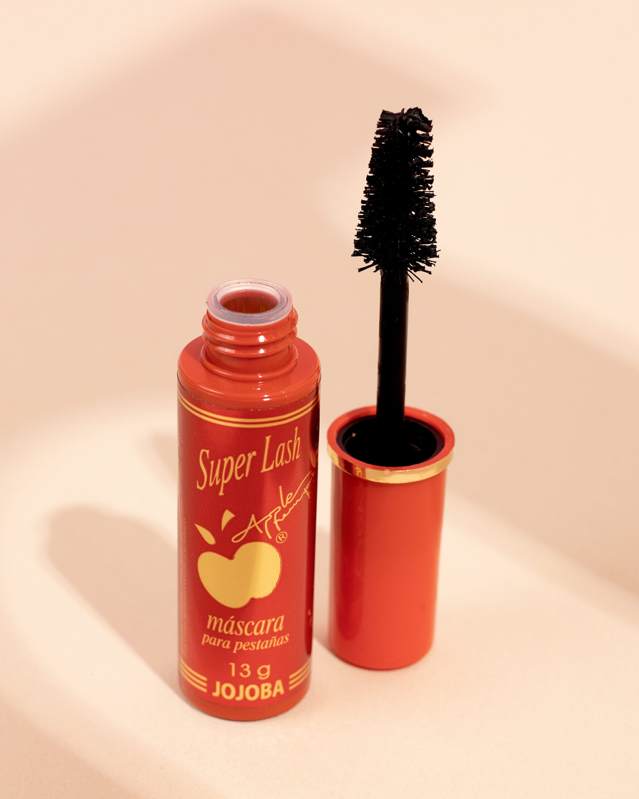 Pestañina Super Lash Apple 13g Jojoba, aplicador negro separado del envase rojo.