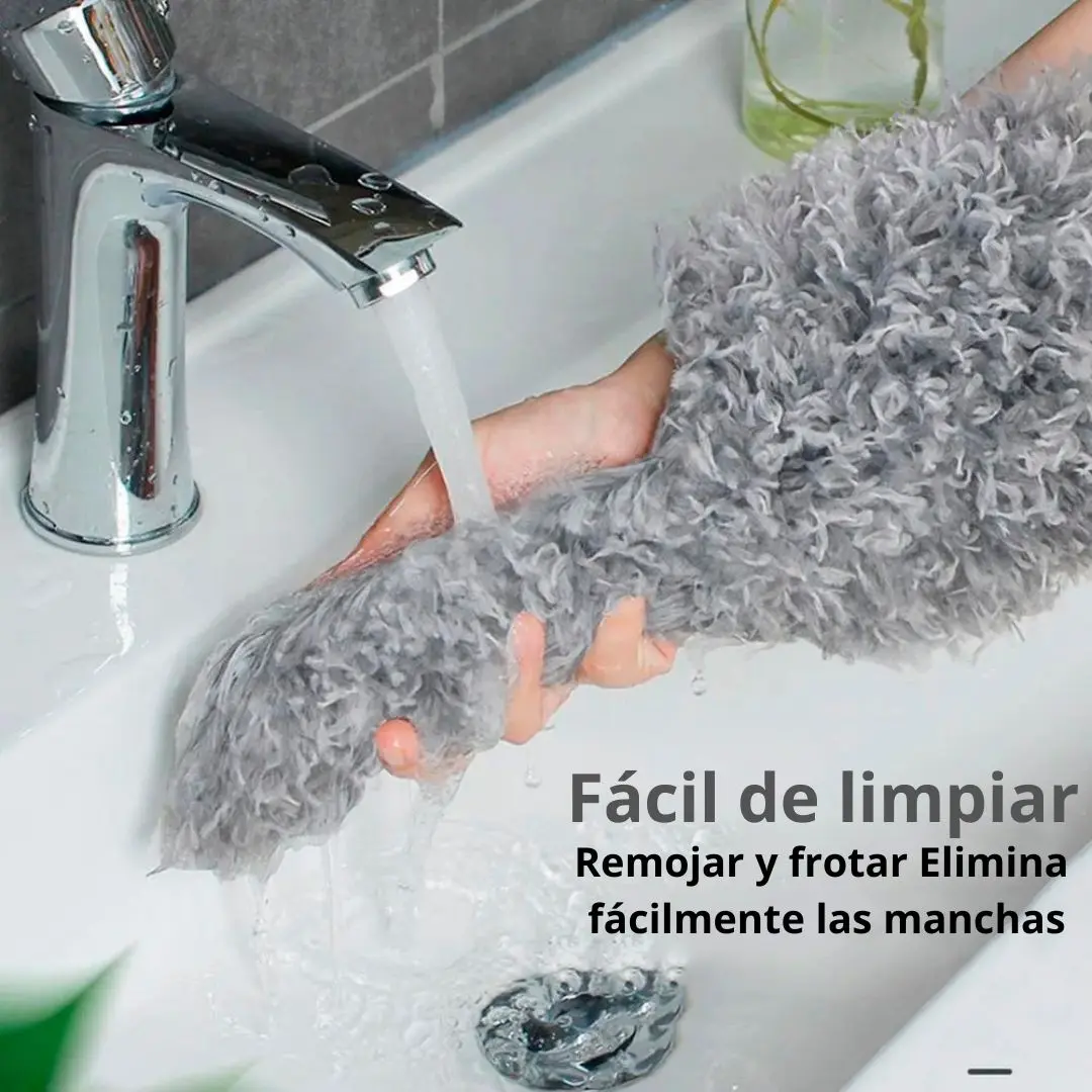 Plumero de microfibra gris suave bajo chorro de agua, ideal para limpiar manchas en el lavabo fácilmente.