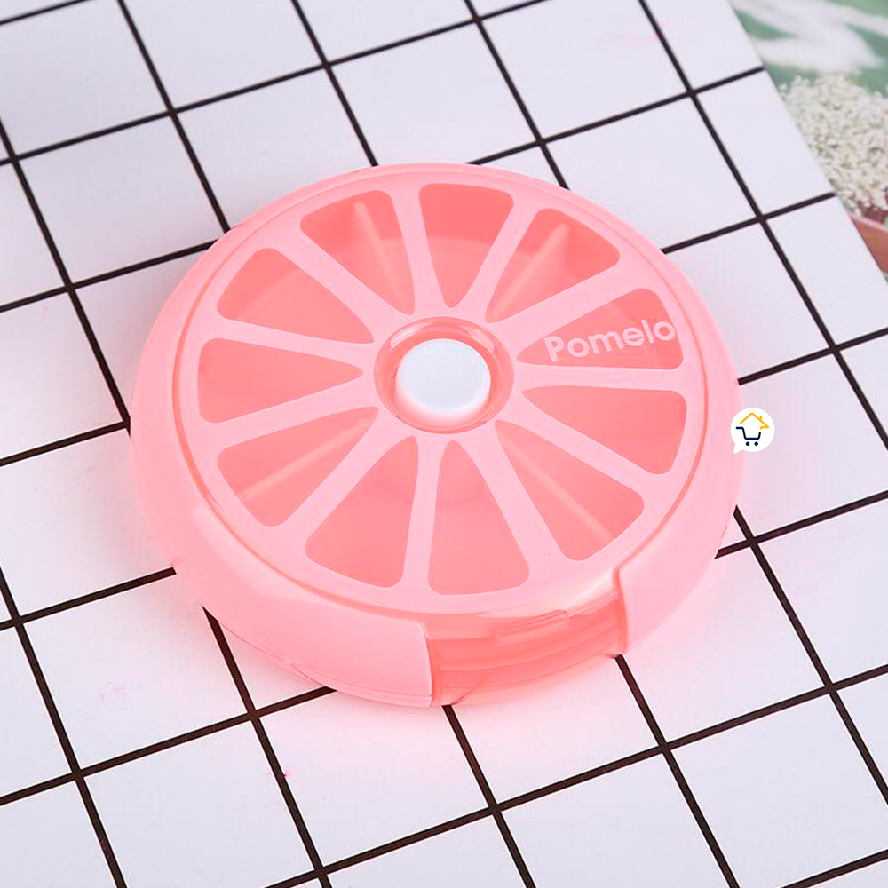 Pastillero semanal rosa con forma de pomelo, 7 compartimentos, tapa blanca central.