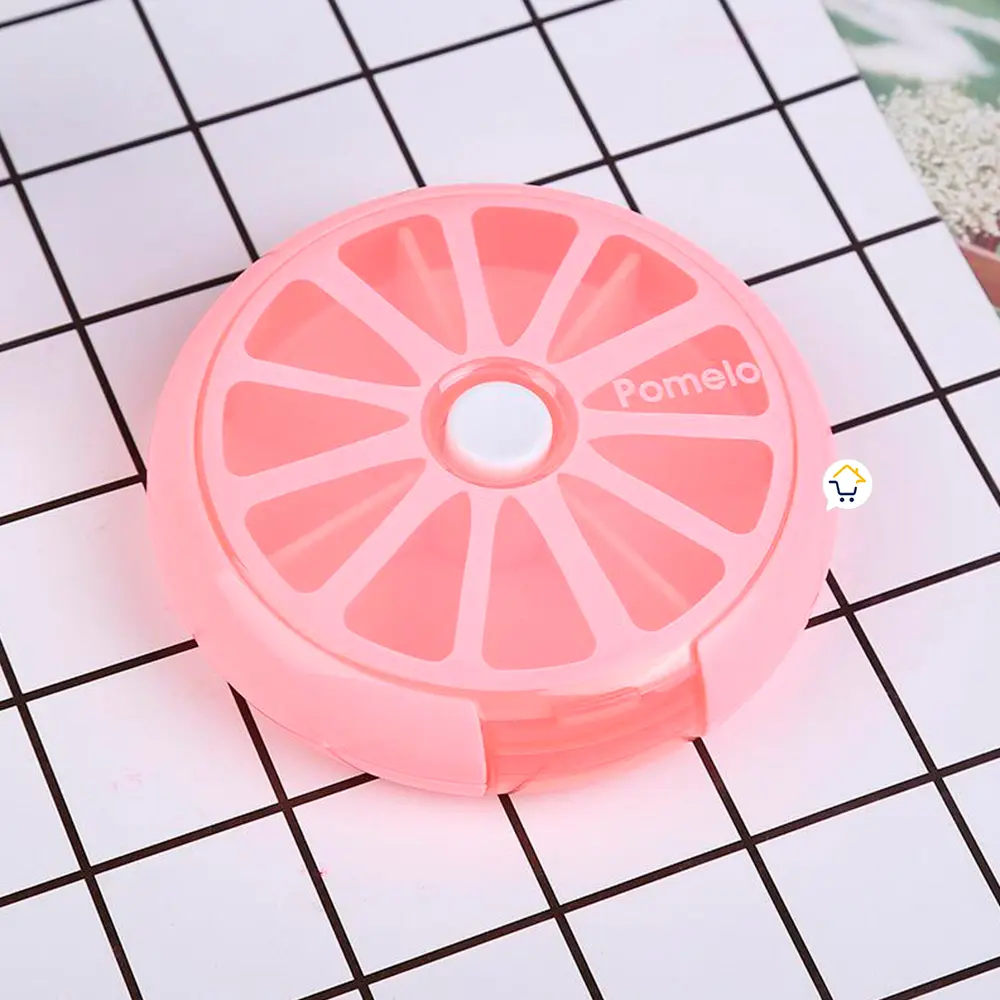 Pastillero semanal rosa con forma de pomelo, 7 compartimentos, tapa blanca central.