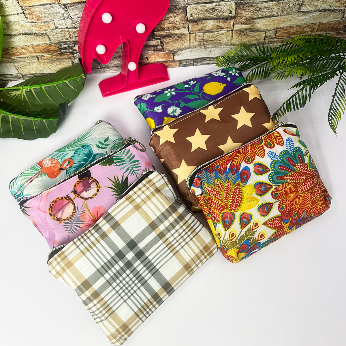Seis bolsos plegables con diseños variados: flamencos, gafas de sol, cuadros, estrellas, limones y pavo real.