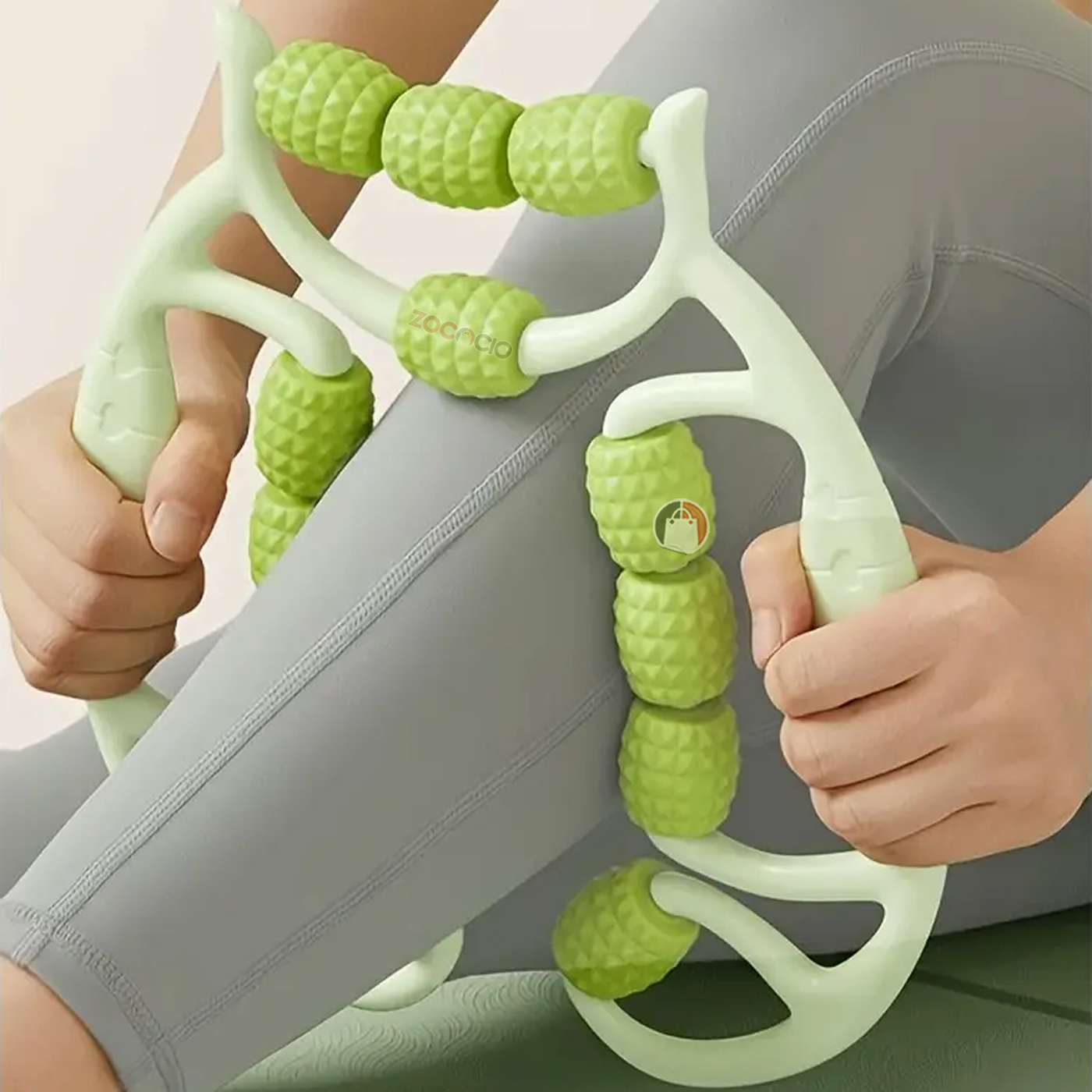 Rodillo de masaje corporal verde con textura tipo piña, usado en pierna, ideal para aliviar tensión muscular.
