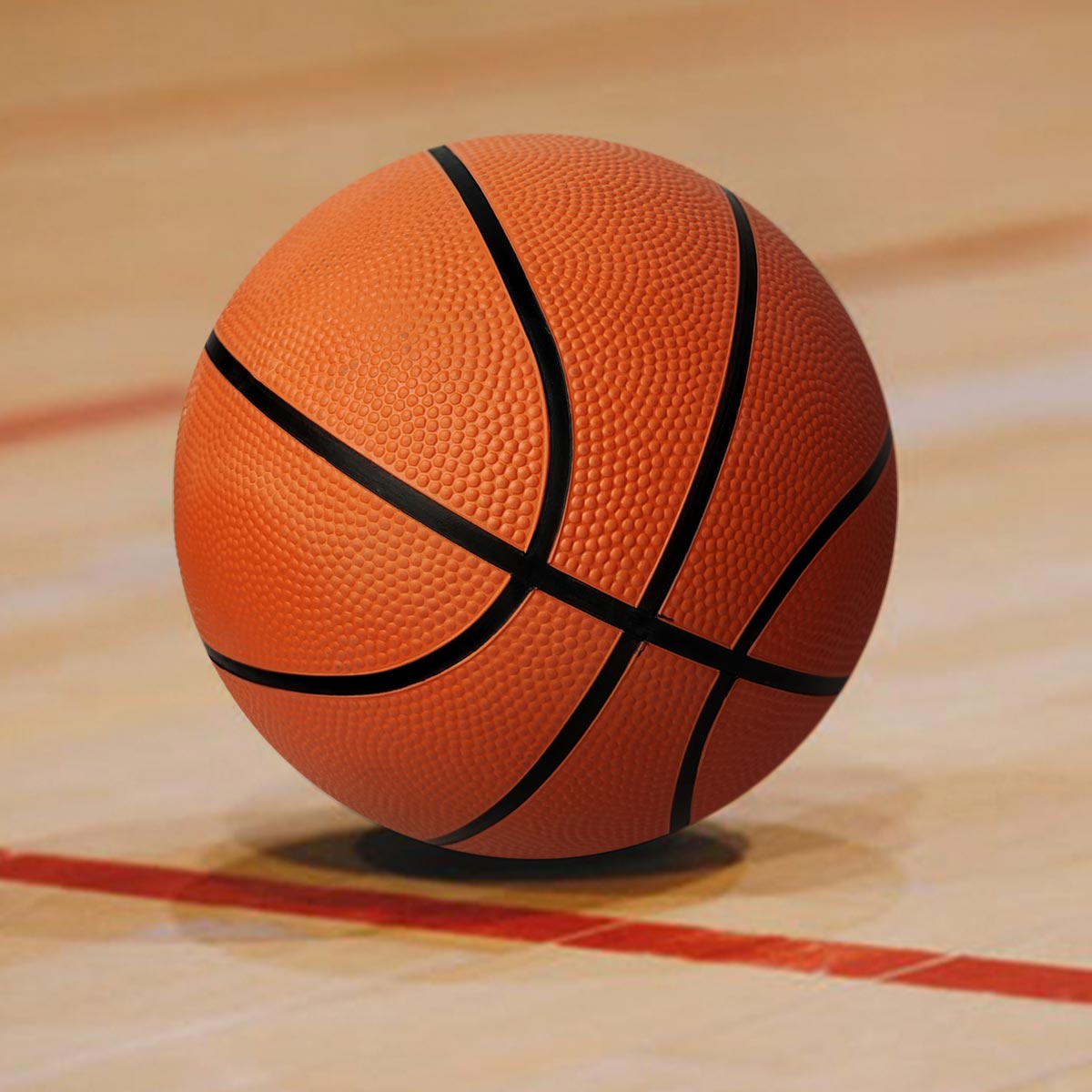 Balón de baloncesto naranja con líneas negras, texturizado, sobre cancha de madera con línea roja.
