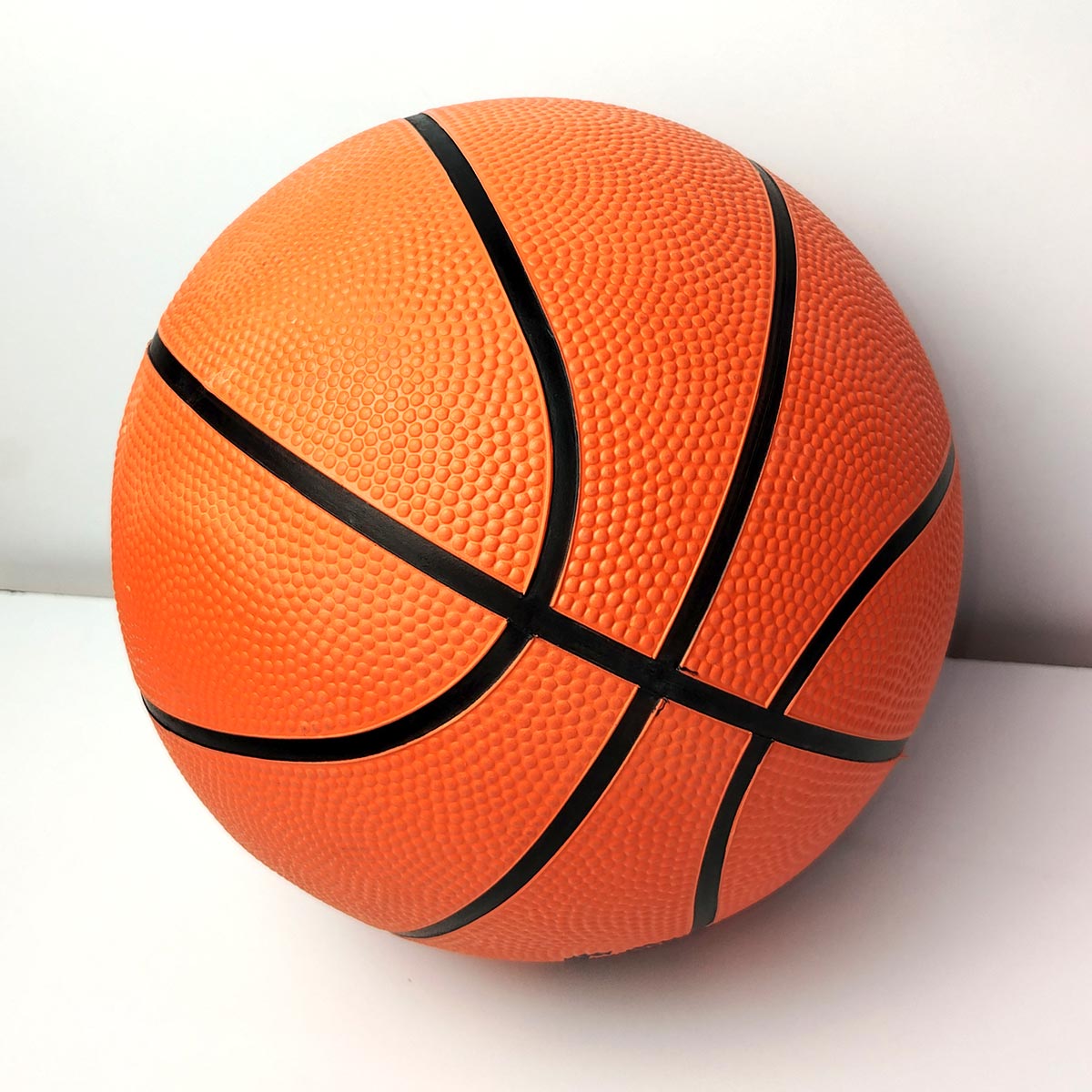 Balón de baloncesto naranja texturizado, tamaño estándar oficial, con líneas negras visibles.