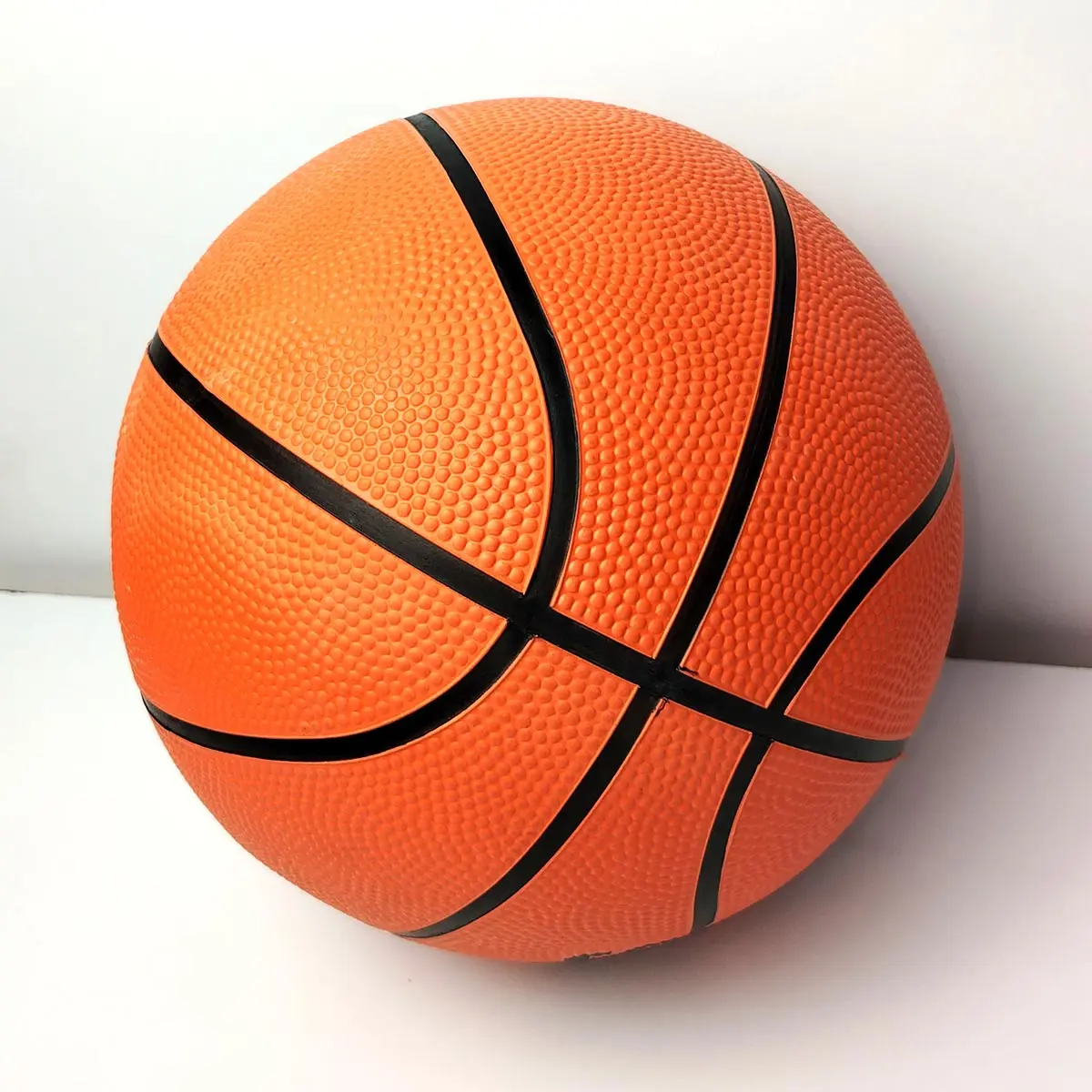 Balón de baloncesto naranja texturizado, tamaño estándar oficial, con líneas negras visibles.