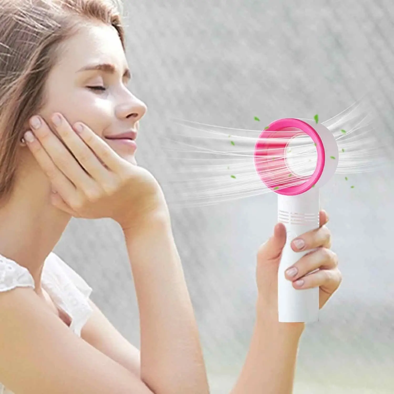 Ventilador de mano sin aspas blanco con borde rosa, emitiendo aire refrescante a una mujer.
