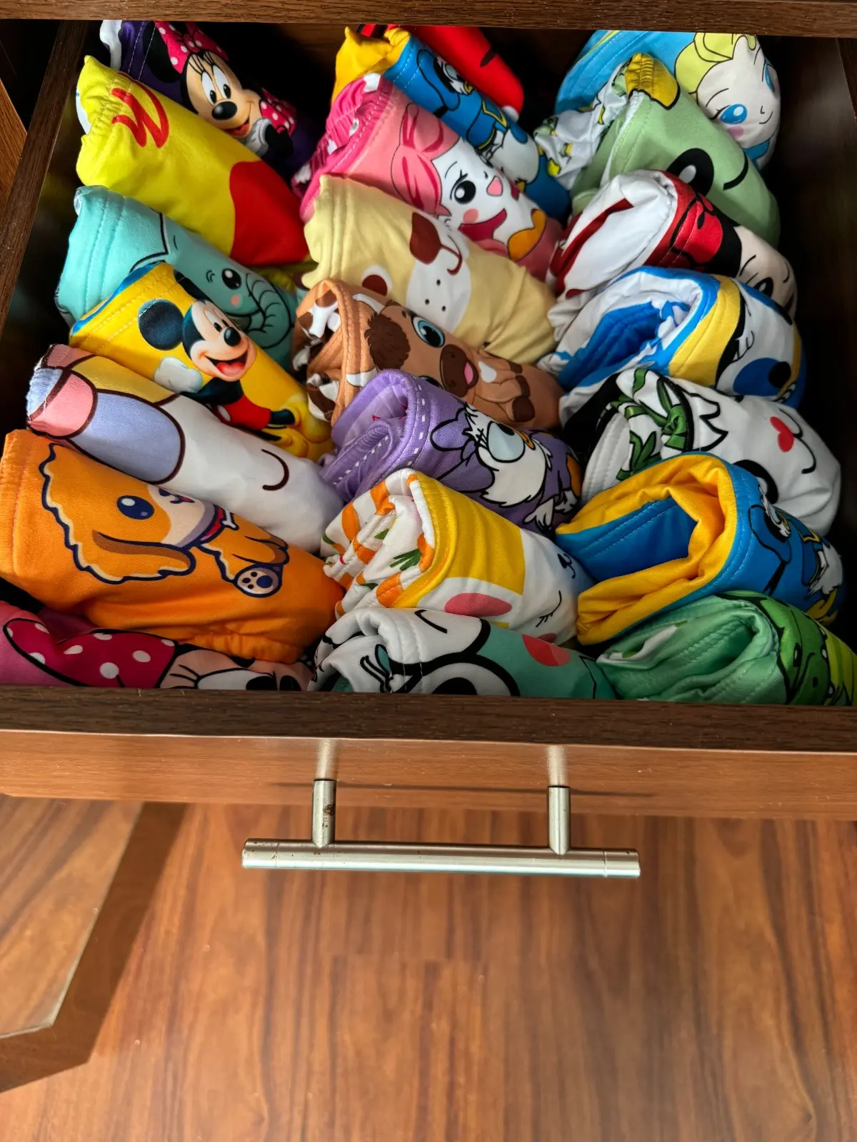 Pantis entrenadores para niños con diseños de Mickey Mouse y otros personajes, organizados en un cajón.