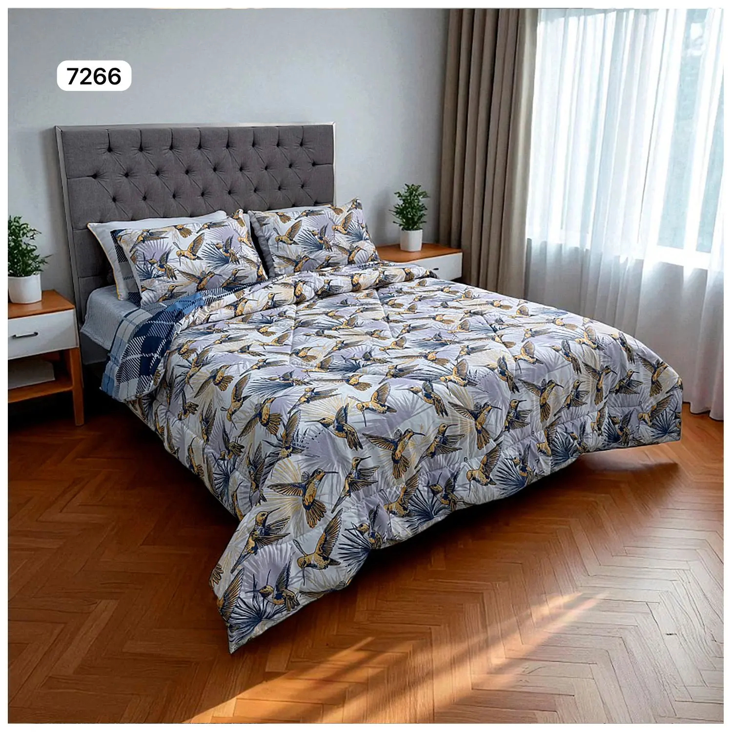 Edredón doble faz para cama doble con estampado de colibríes y hojas tropicales en tonos grises, azules y dorados.